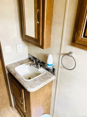 Une petite salle de bain comprenant un lavabo, un meuble et un porte-serviettes.