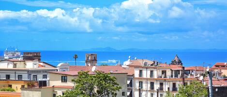 A coastal town with buildings, a clear sky, and the sea in the background.