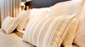 Una cama con almohadas a rayas y un cubrecolcha acolchado.