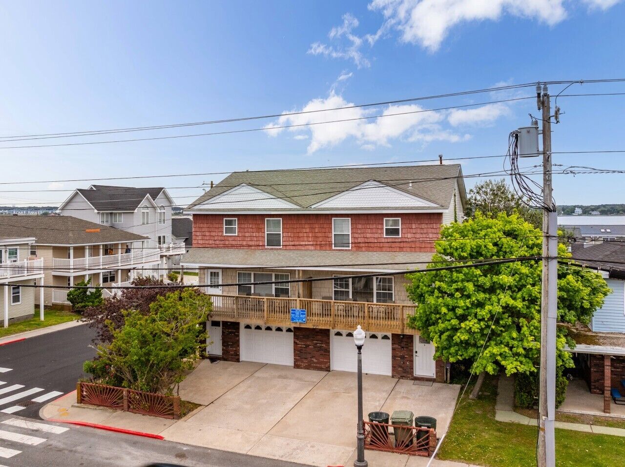 Un immeuble résidentiel à structure de deux étages, doté d’un balcon et d’un garage.