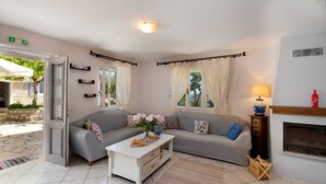 Ein gemütliches Wohnzimmer mit grauem Sofa, einem weißen Couchtisch und einem Kamin.