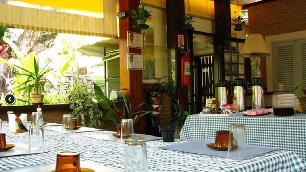 A restaurant with checkered tablecloths, outdoor seating, and various plants and decorations. - Pousada Seachegue (Ubatuba)