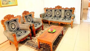 A room with a sofa set, a coffee table, and a rug. - Rachella Homestay (Tanah Datar)