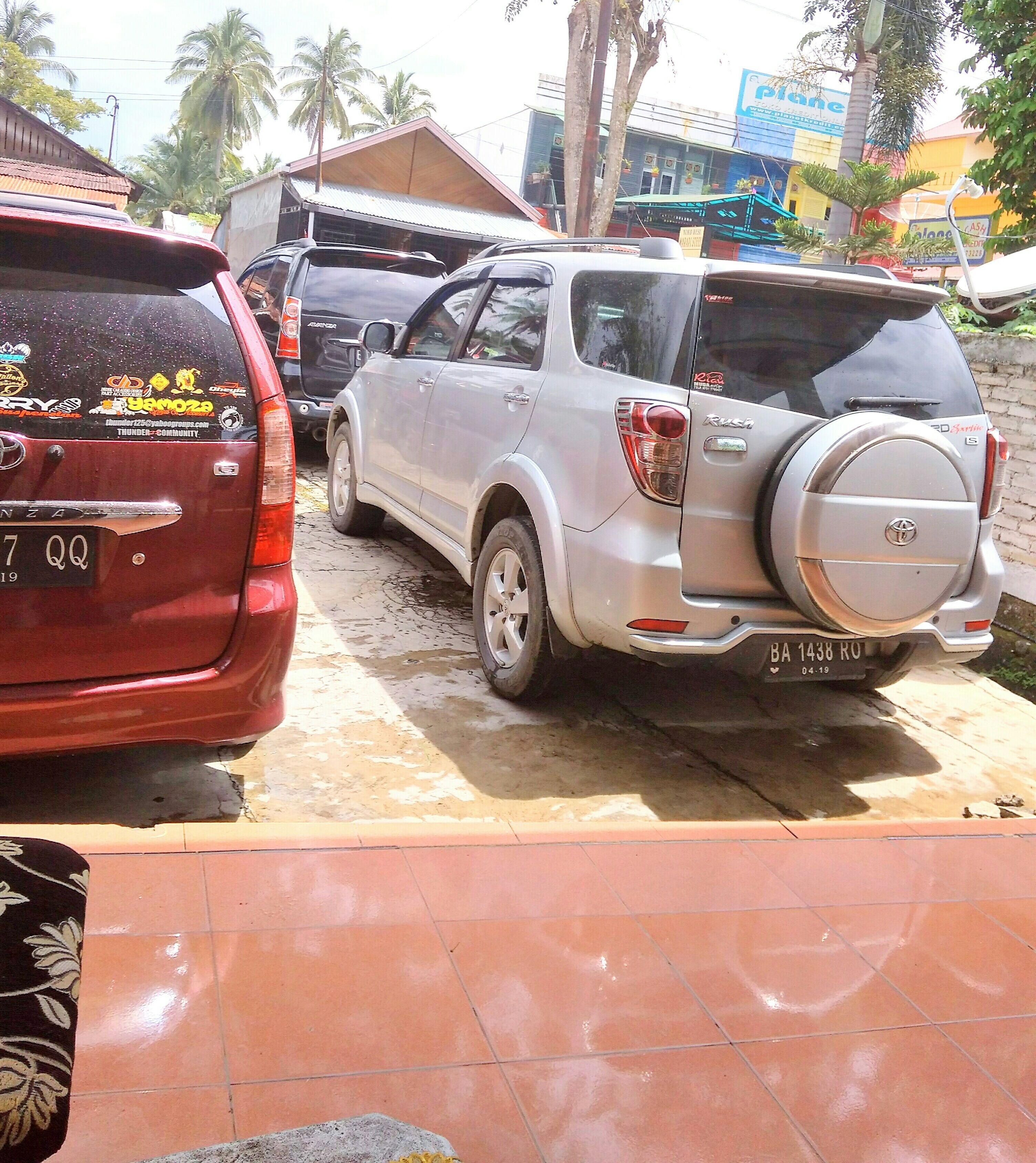 A parking area with several vehicles, including a red SUV and a silver SUV.