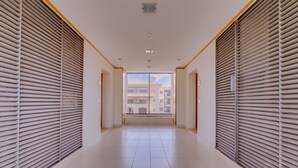 A corridor with closed blinds, a tiled floor, and a view through the blinds. - Amazing apartment in Victoria Boulevard (Vilamoura)