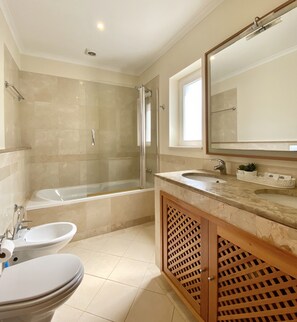 A modern bathroom with a bathtub, a sink, and a toilet. - Amazing apartment in Victoria Boulevard (Vilamoura)