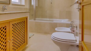Een moderne badkamer met toilet, wastafel en bad.
