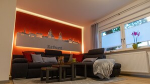 Un soggiorno con un divano, un tavolino da caffè e un murale raffigurante un panorama urbano.