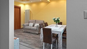 Un comedor con una mesa, sillas, un sofá y una planta.