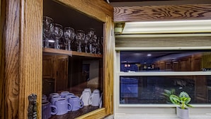 A wooden cabinet with shelves holding wine glasses and mugs. - Kenny's Mountain Hideaway w/ Hot Tub, Arcade, Fireplace, Views, & 10 King Beds (Sevierville Tennessee)