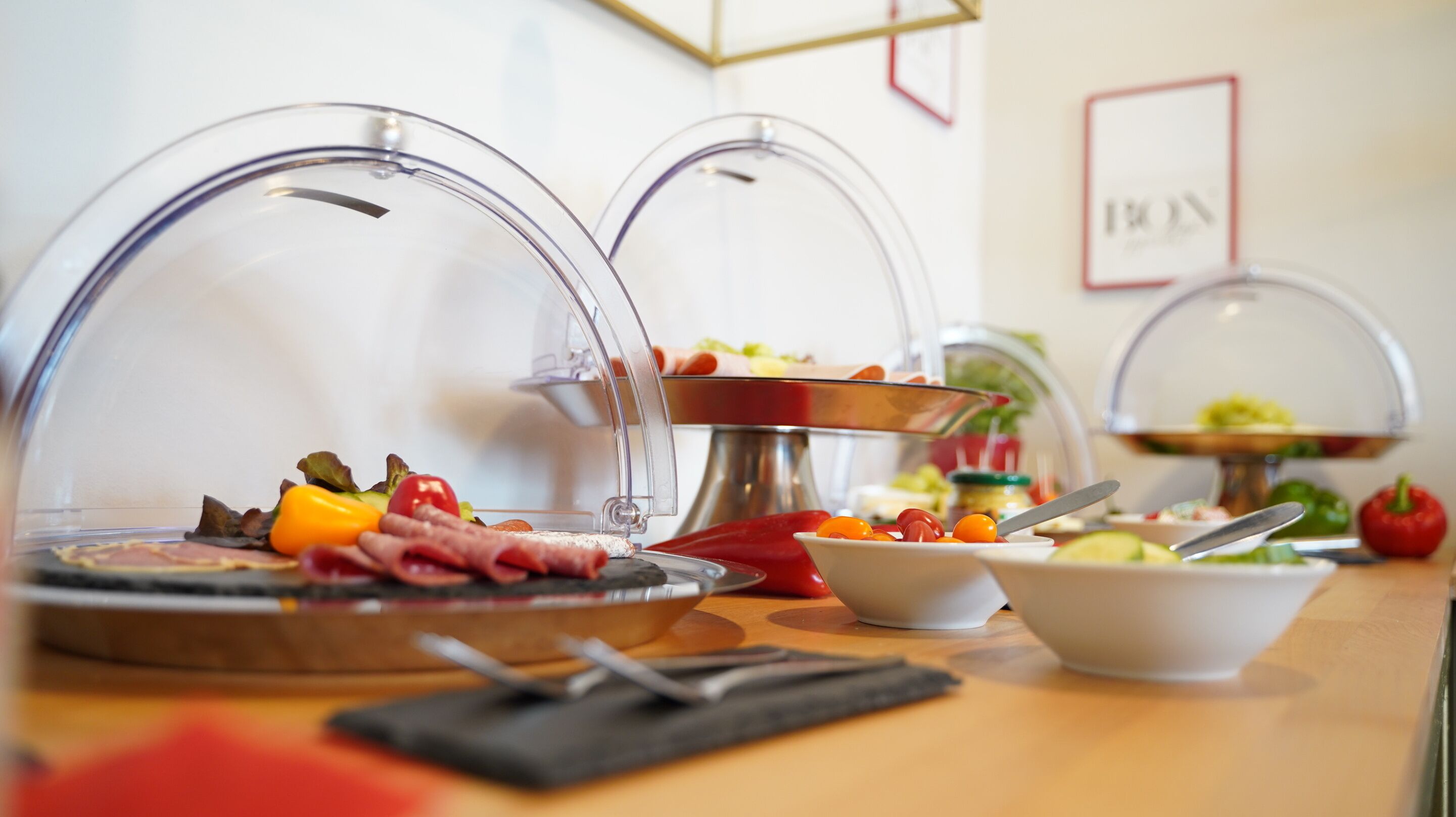 Ein reichhaltiges Buffet mit verschiedenen Speisen unter Glasglocken.