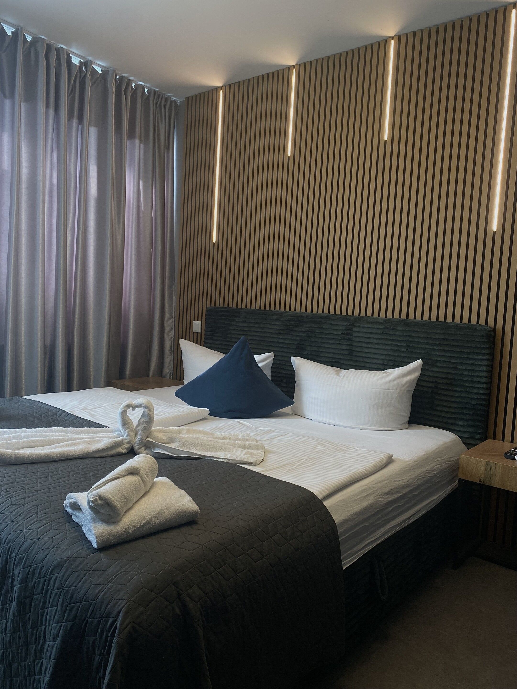 Ein Hotelzimmer mit einem großen Bett, einem Kopfteil und einem Nachttisch.