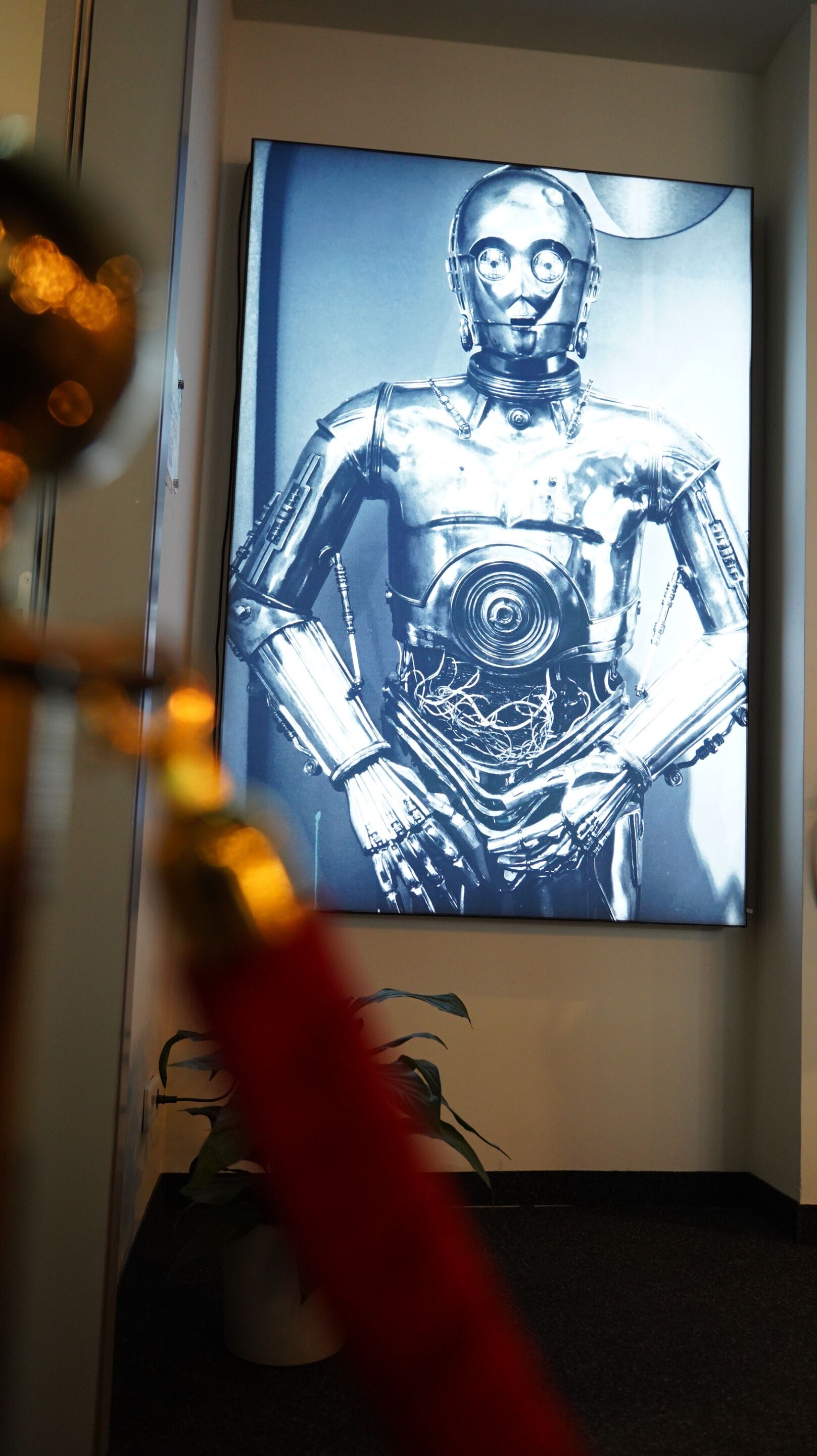 Une œuvre d’art encadrée représentant un robot métallique, accrochée à un mur.