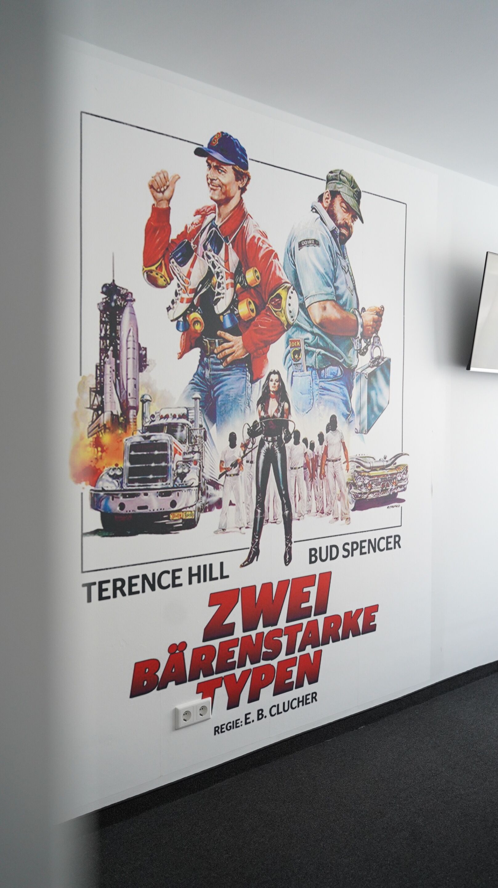 A poster with characters and text, including names like Terence Hill and Bud Spencer, and the title "Zwei Bärenstarke Typen".