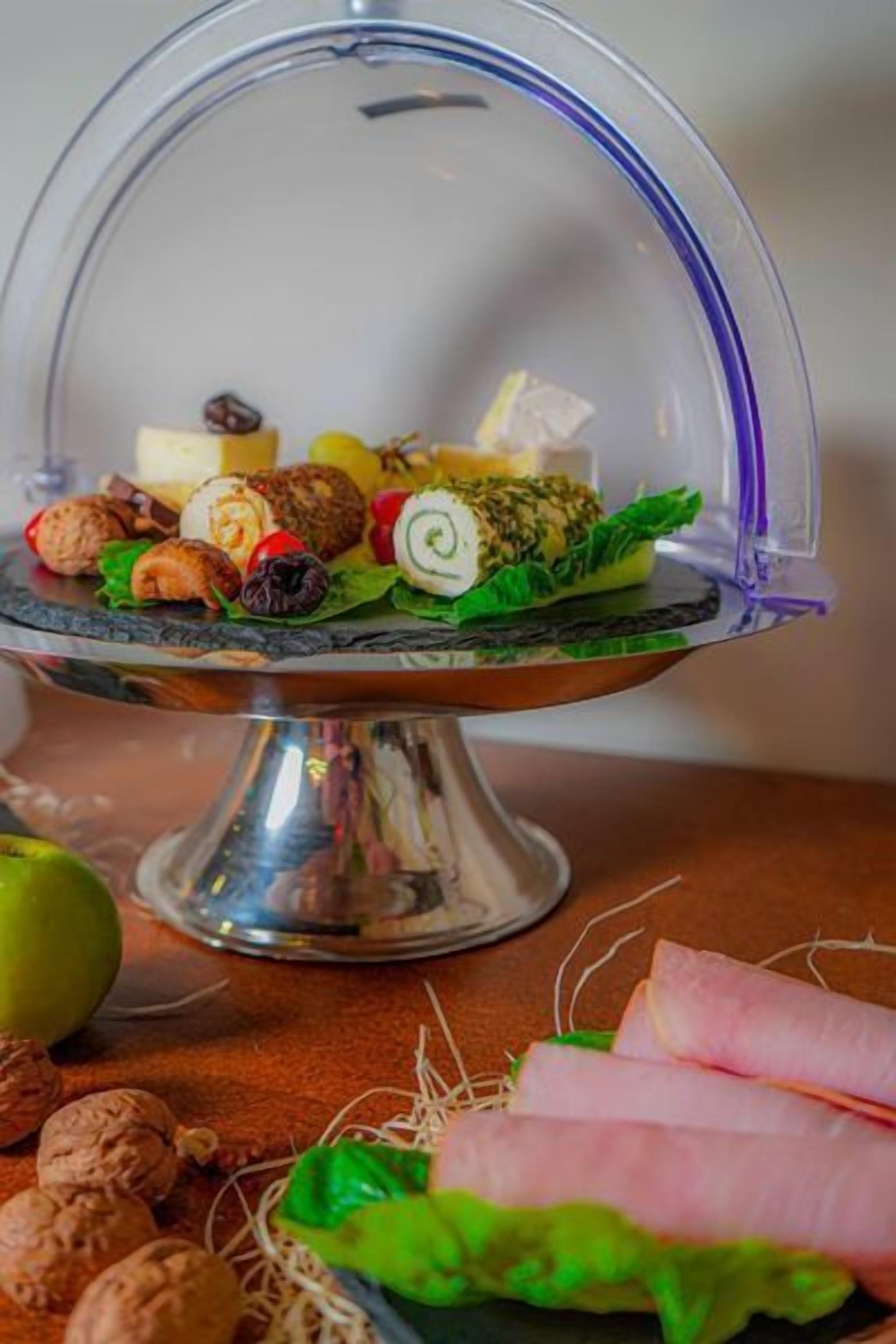 Un plateau de desserts comprenant divers bonbons et fruits, présenté sur un présentoir en métal.