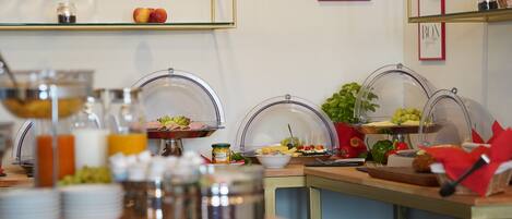 Montaje de bufé con distintos alimentos y un letrero de cocina al fondo.