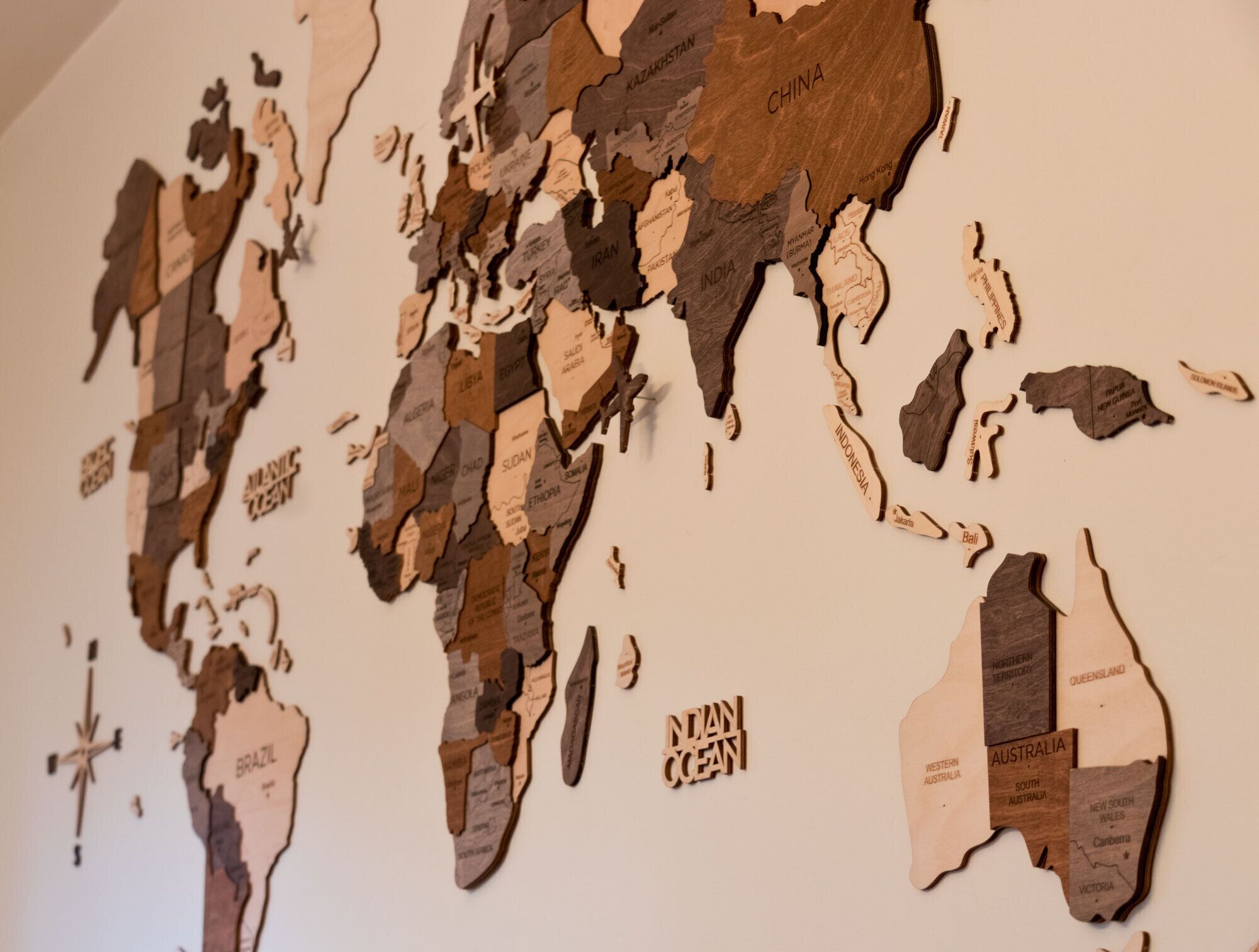 A world map made of wood pieces, with country names labeled.