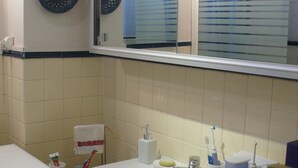 A bathroom with a sink, mirror, and a window. - Typical Parisian neighborhood Easy access (Paris)