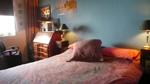 A bedroom with a bed, a dresser, a lamp, and a window. - Typical Parisian neighborhood Easy access (Paris)