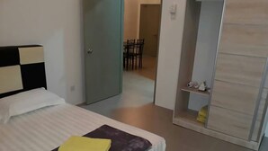 A bedroom with a bed, a wardrobe, and a bathroom visible through an open door. - Marina Barrington sq aprt at pasar malam Tanah Rata Cameron Highland (Tanah Rata)