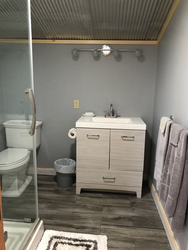 A bathroom with a toilet, sink, and shower.