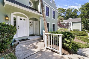A two-story house with a front porch, a mailbox, and a well-maintained lawn.