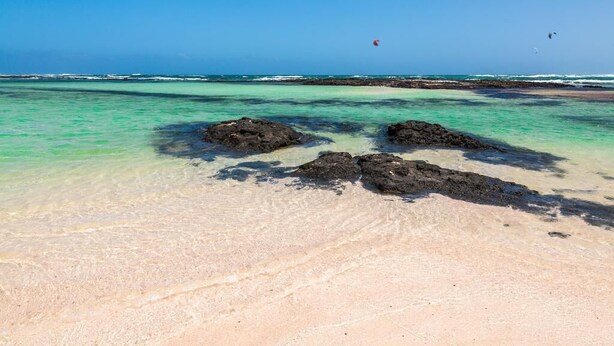A beach with clear turquoise water, rocky outcrops, and a distant view of the ocean. - Penthouse Casa Orymar El Cotillo (El Cotillo)