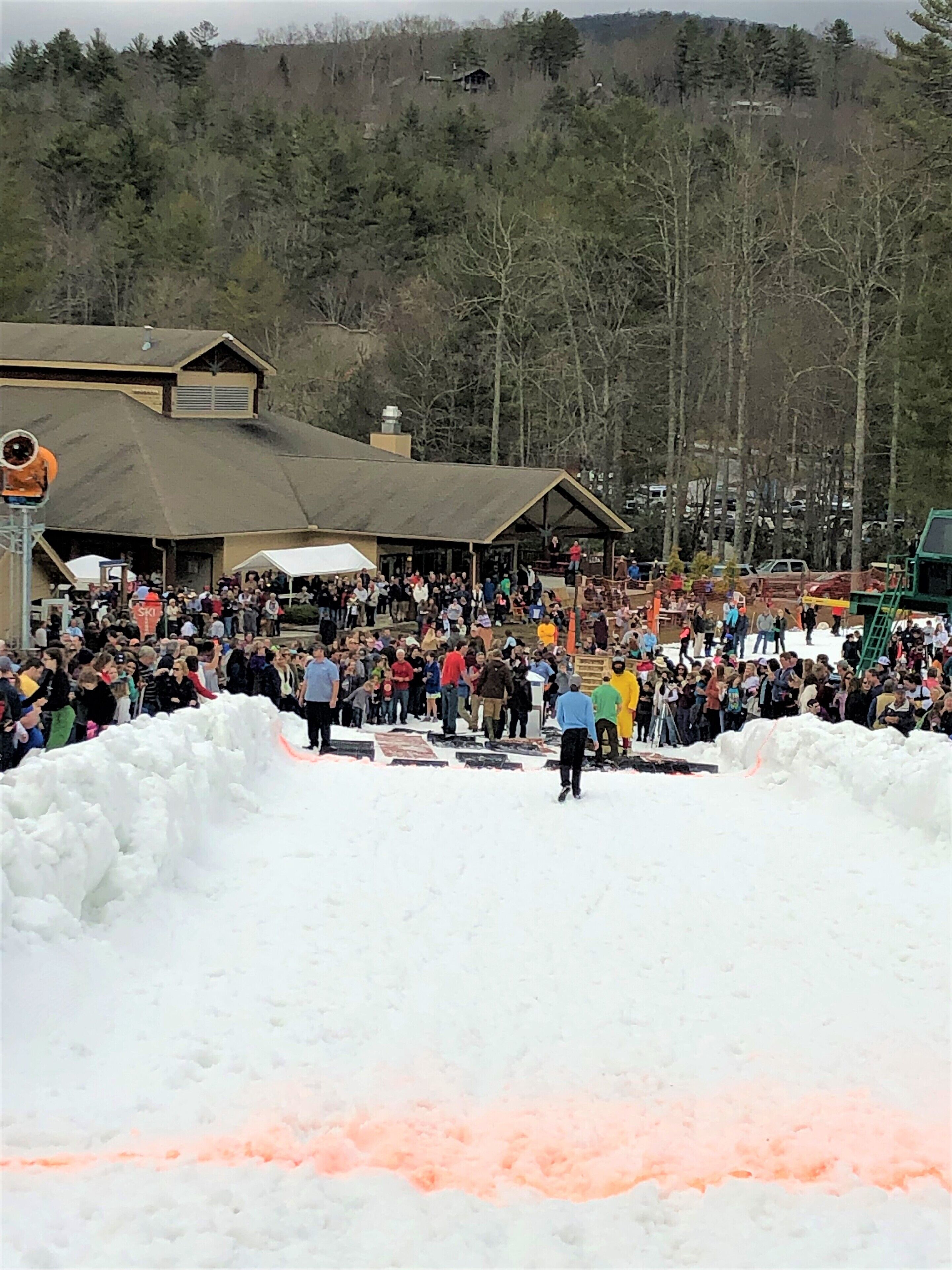Un événement en plein air, sous la neige, où une foule s’est rassemblée autour d’une scène.