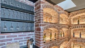 A brick wall with wine bottles and glasses displayed. - Beachfront Villa New Horizons II (Murter)
