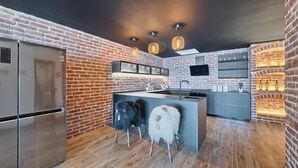 A modern kitchen with a brick wall, stainless steel appliances, and a central island. - Beachfront Villa New Horizons II (Murter)