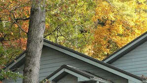 A house with a porch, a welcome sign, and a '3 Club Parking' sign. - Three Cub Cottage in historic Flat Rock (Flat Rock)