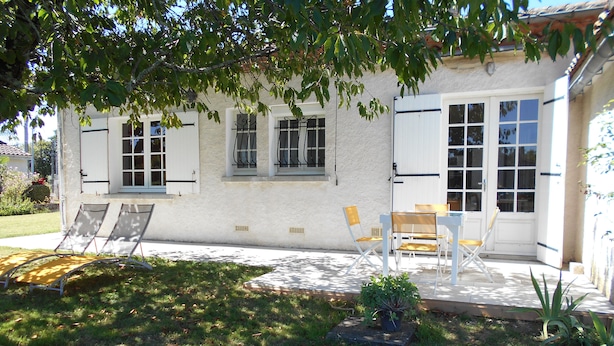A house with a patio, a lawn, and a small garden. - Gîte Le Penten (Villeréal)