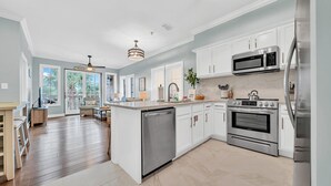 A spacious kitchen with white cabinetry, stainless steel appliances, and a large island.