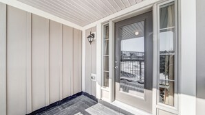 A modern entrance with a glass door, a small balcony, and a light-colored exterior wall. - Executive Town Home - Historical Snowbridge Village, Mountain View Blue mountain (The Blue Mountains)