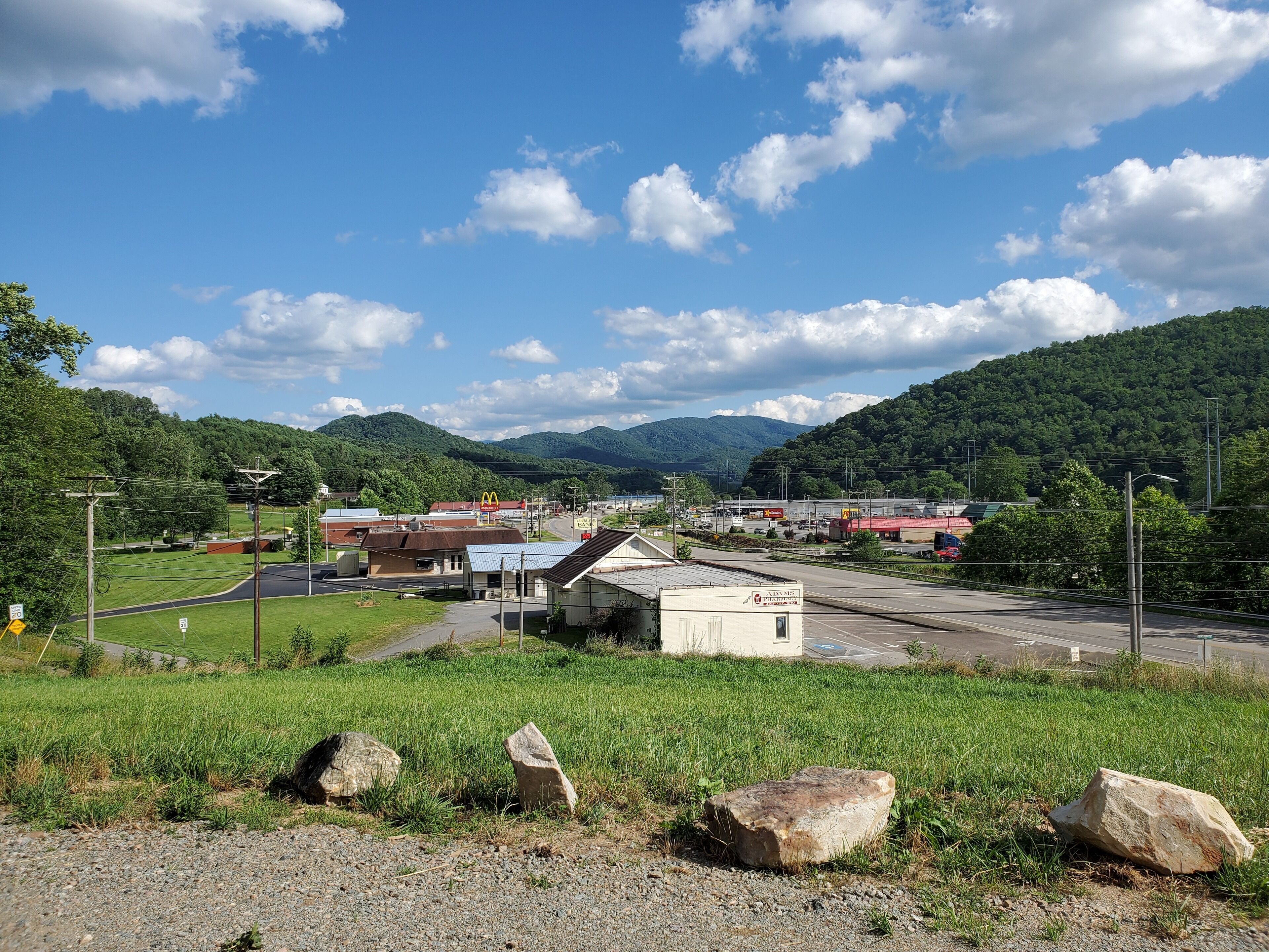 A rural landscape with a small building, a McDonald's, and a parking lot.