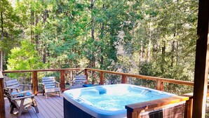 A hot tub on a wooden deck surrounded by trees. - The Creek-Side Cabin: Hot Tub, Fire Pit,5 Star, AC, Big Deck, Quiet,Walk To Town (Idyllwild-Pine Cove)