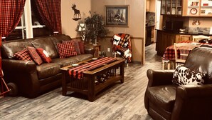 A cozy living room with a leather sofa, a wooden coffee table, and a fireplace.