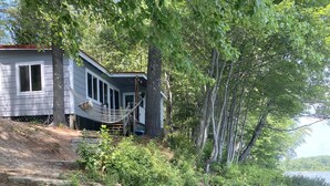 A lakeside property with a house, clear water, and a dock. - Lakeside home. Fishing, paddle boarding, swimming, and easy lake  fun.  (Warner)
