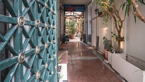 A corridor with a green metal gate, potted plants, and a sign for 'baresera'. - Polytimon, an Athenian Neoclassical Apartment (Athens)