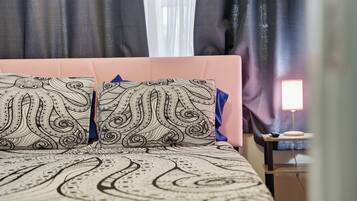 Een bed met beddengoed met een patroon en een nachtkastje met een lamp.