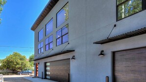 Ein modernes, zweistöckiges Gebäude mit großen Fenstern und einer Garage.