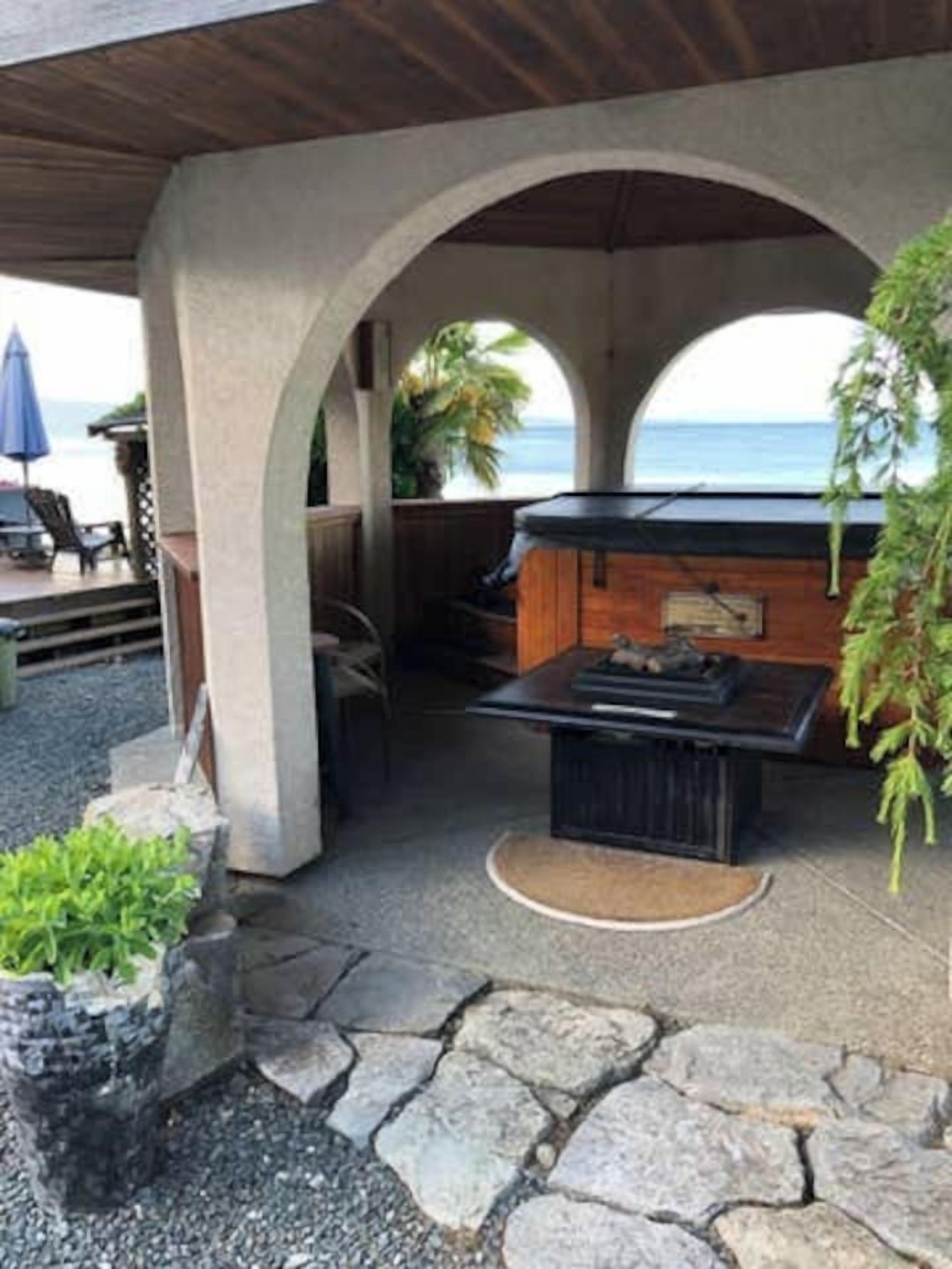 Un espace extérieur aménagé en terrasse, avec un sol en pierre, une table en bois et un barbecue.