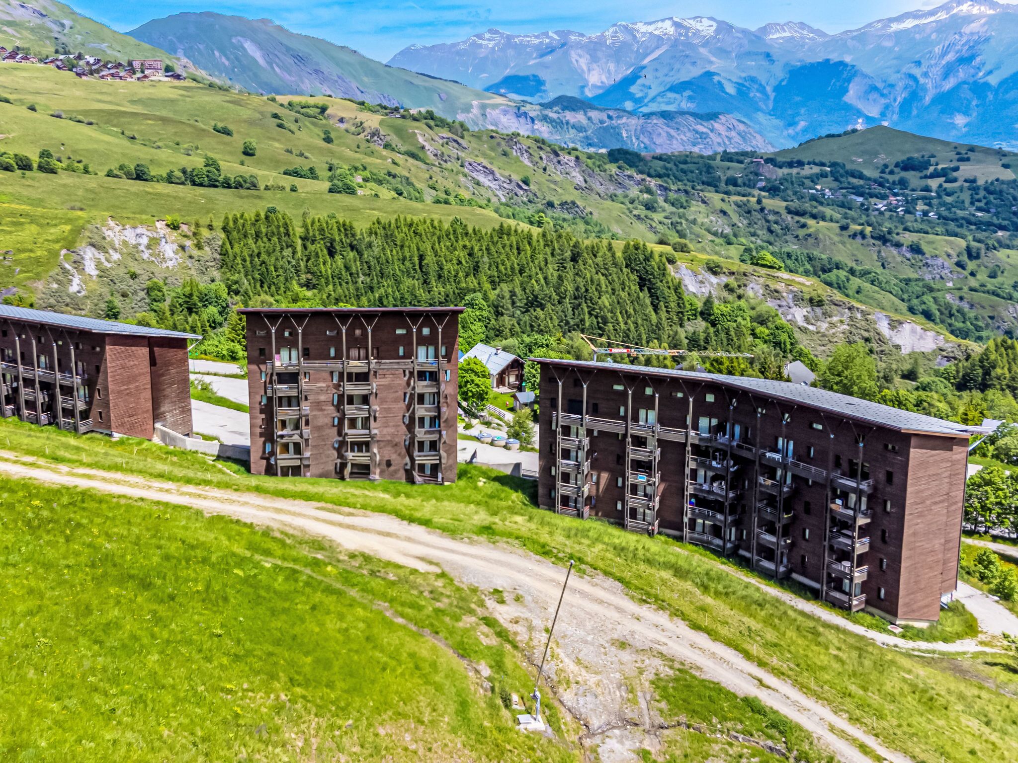 Un bâtiment moderne doté de nombreux balcons et offrant une vue sur un paysage montagneux.
