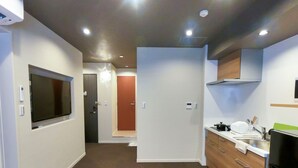 A compact kitchen with a microwave, stove, sink, and cabinets.