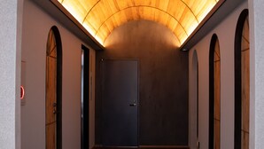 A hallway with a wooden ceiling, arched doorways, and a tiled floor. - Hotel S-presso South (Osaka)