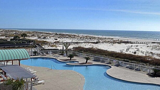 Ein Poolbereich mit Blick auf Strand und Meer.
