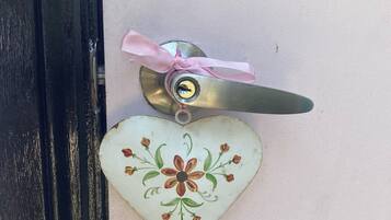 A door with a heart-shaped decoration featuring a floral design and a pink ribbon.