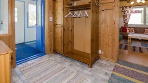 Een houten interieur met een kledingkast, een hanggedeelte en een bank.