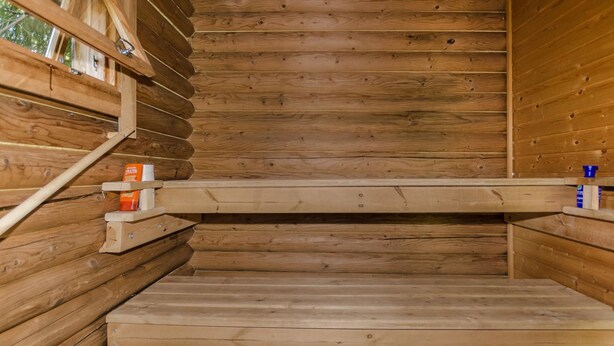 Een houten sauna met banken en een houten vloer.