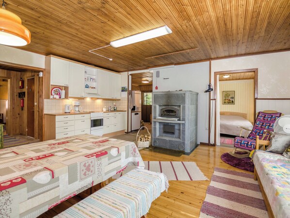 A cozy room with a bed, a fireplace, and a kitchen area.